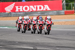 Lima pebalap muda Indonesia dari Astra Honda Motor membalap beriringan di lintasan Thailand Talent Cup 2025 dengan motor balap berwarna putih merah.
